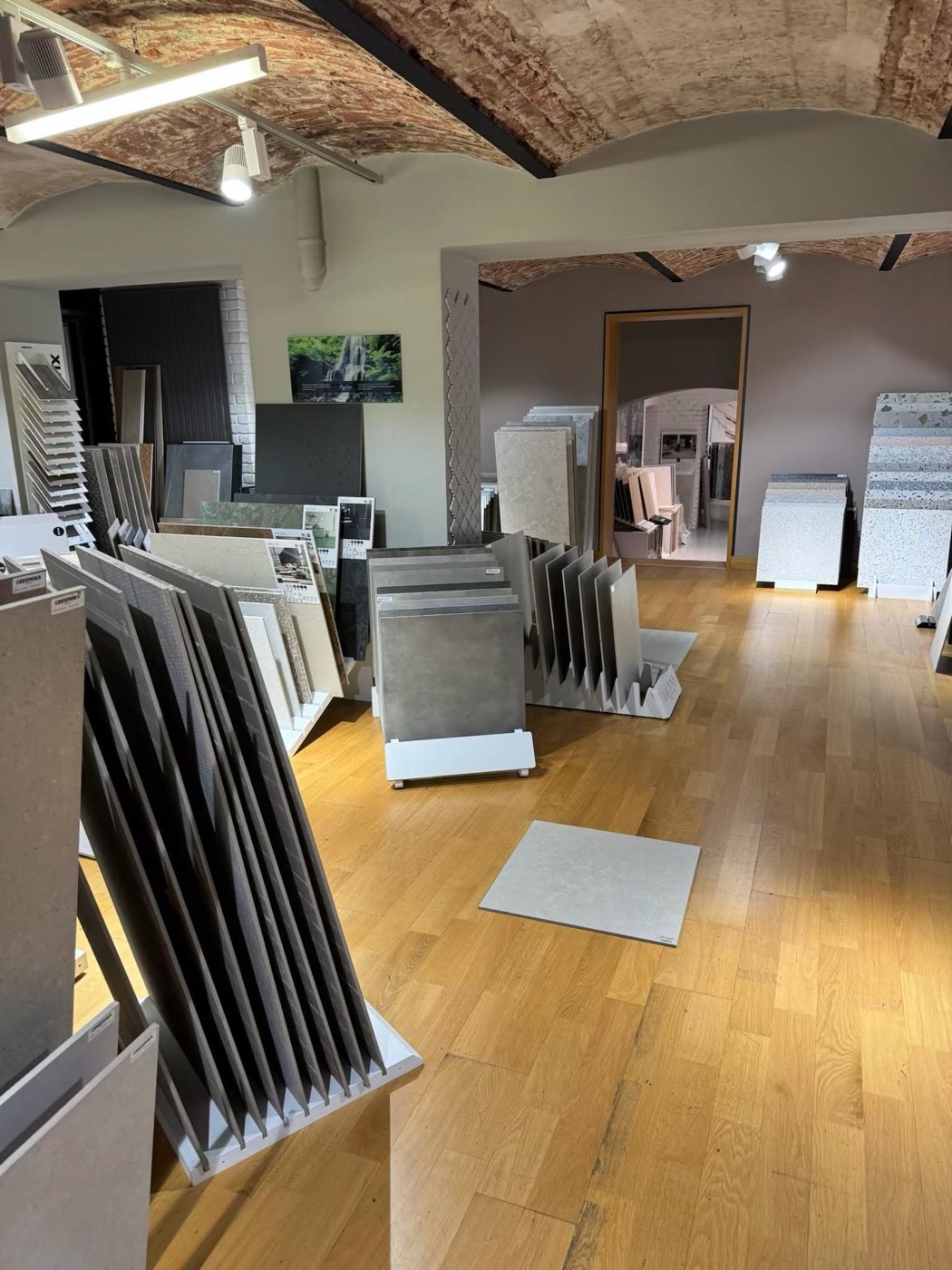 Showroom s obklady a dlažbou pod klenutým cihlovým stropem